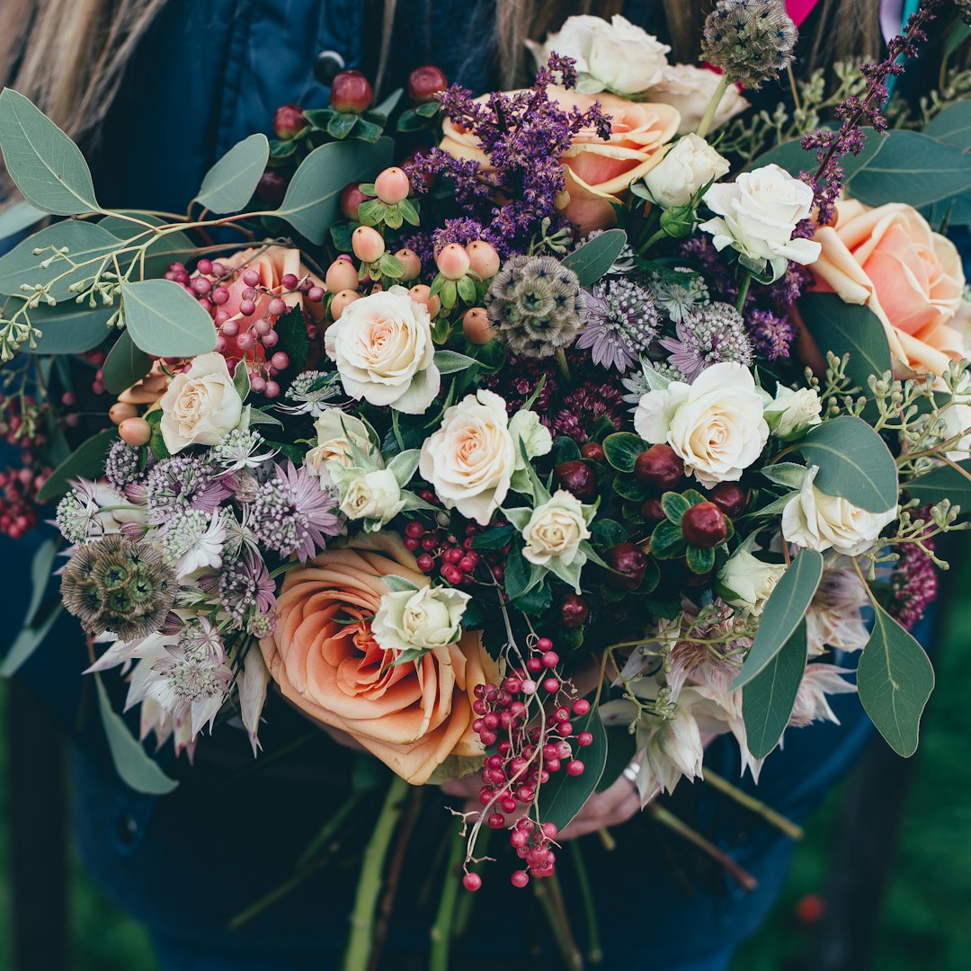 Coral and cream garden-style bouquet held by a florist